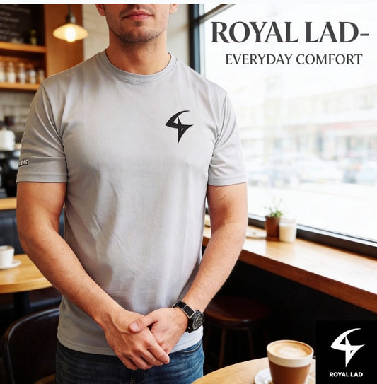 Man wearing a gray t-shirt with a logo in a cafe setting, featuring 'Royal Lad' branding.